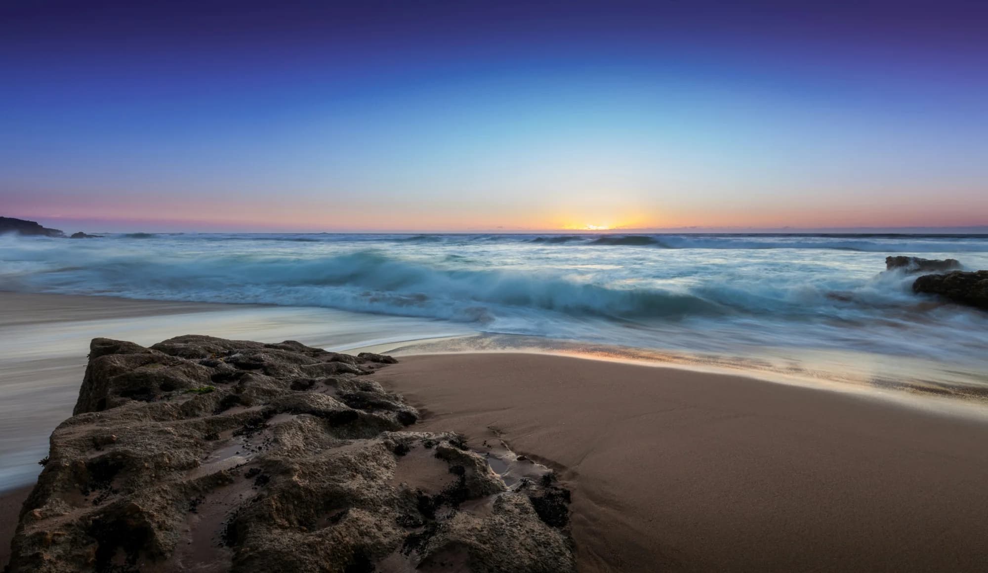 Sunset over the sea and rocks at Praia do Guincho